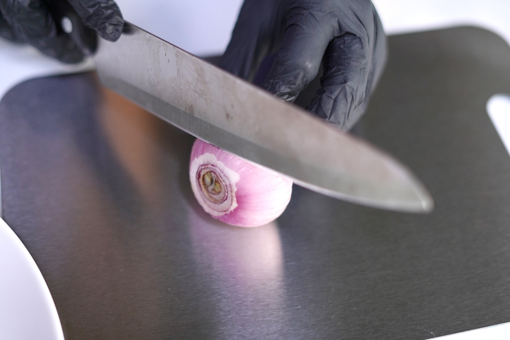 CuttingFreshOnionSlicesOnTitaniumCuttingBoardWithKnife - welltica.dk - Vejen til et bedre liv