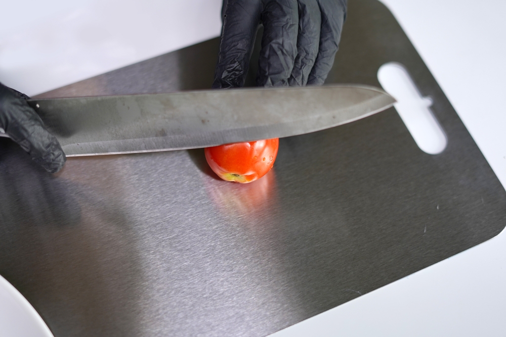 SlicingFreshTomatoesOnTitaniumCuttingBoardWithKnifePreparing - welltica.dk - Vejen til et bedre liv