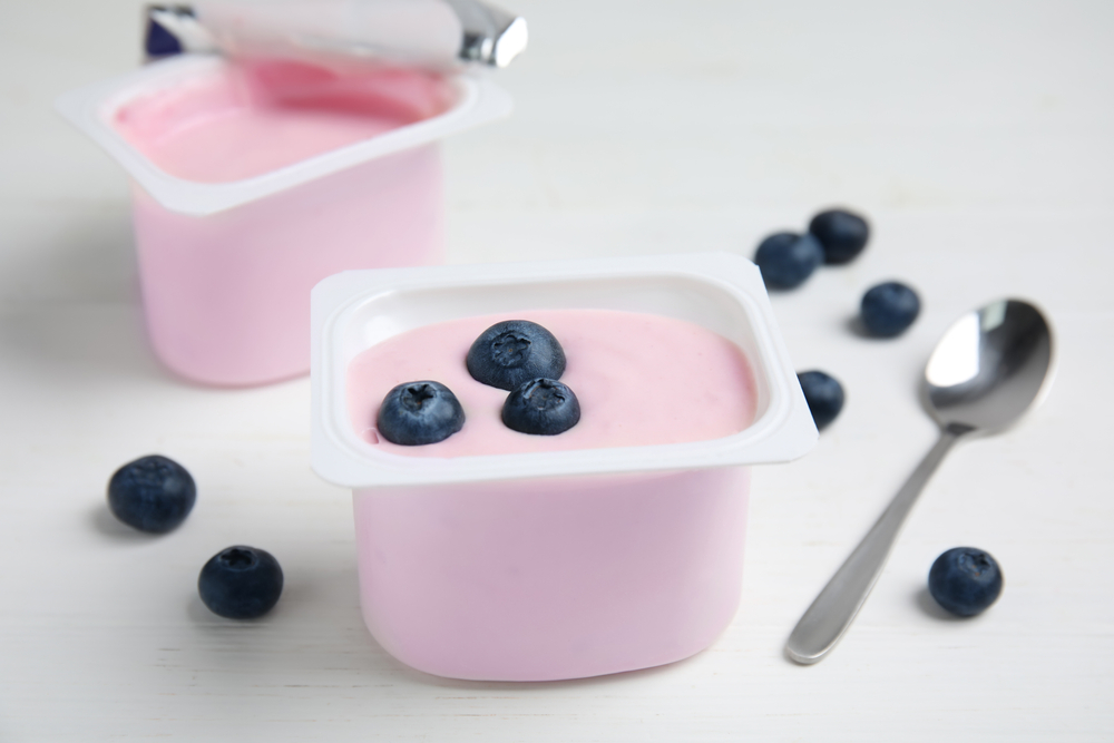 PlasticCupWithTastyYogurtAndBlueberriesOnWhiteWooden - welltica.dk - Vejen til et bedre liv