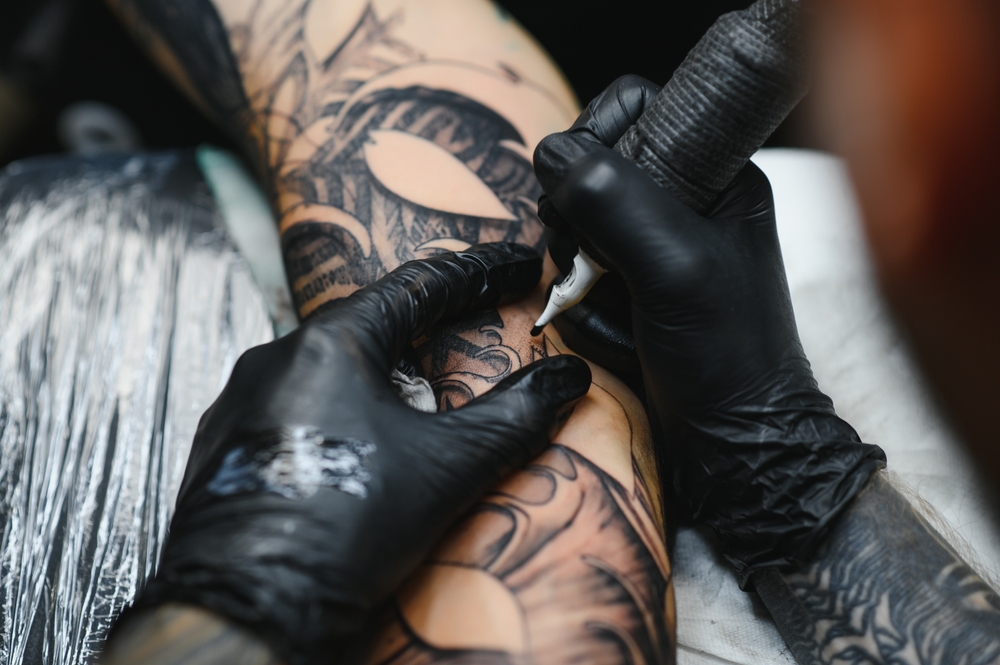 CroppedCloseUpOfABeardedTattooArtistWorkingAt - welltica.dk - Vejen til et bedre liv